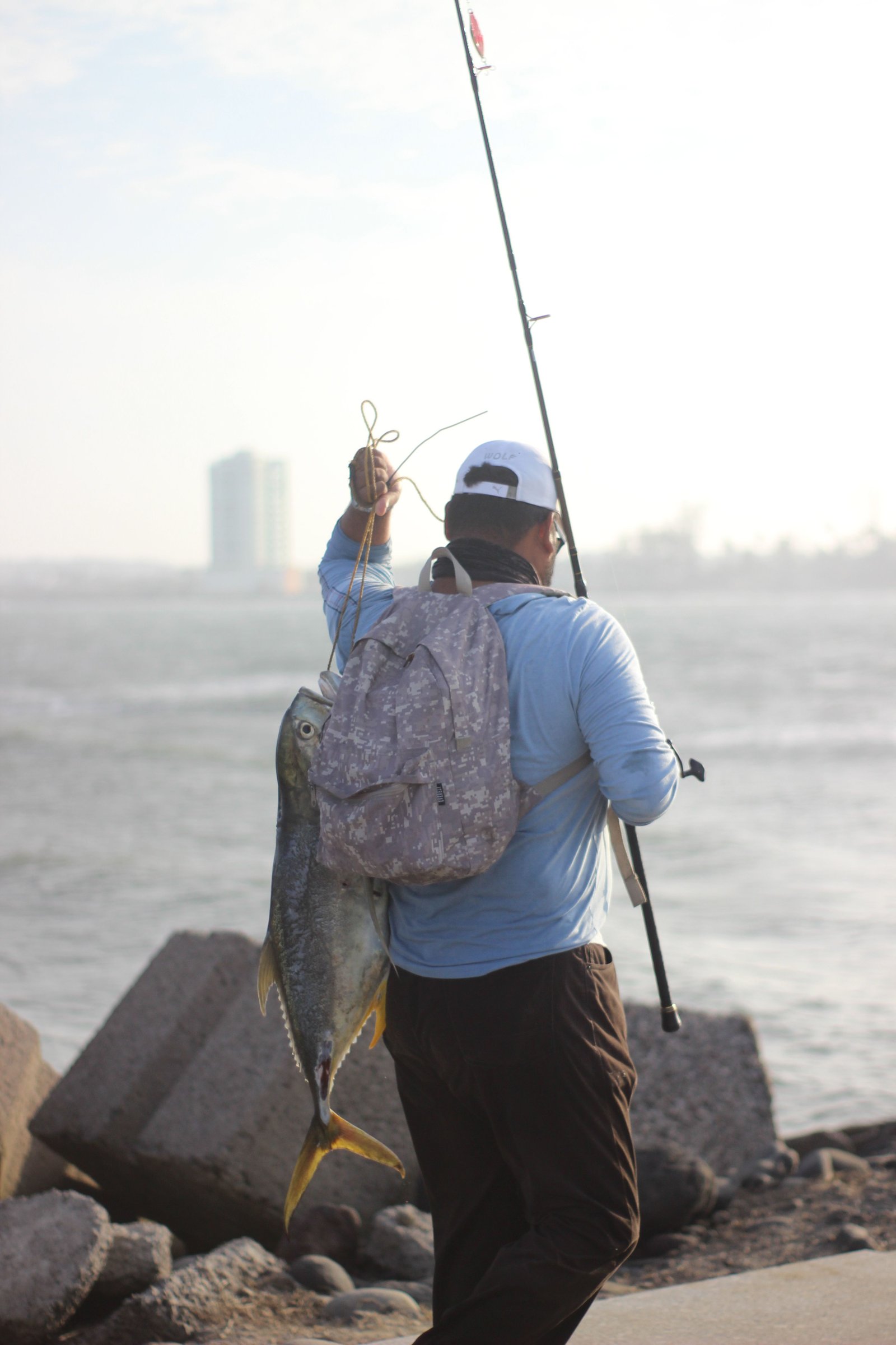 Angler carrying a fresh catch along the jetty
