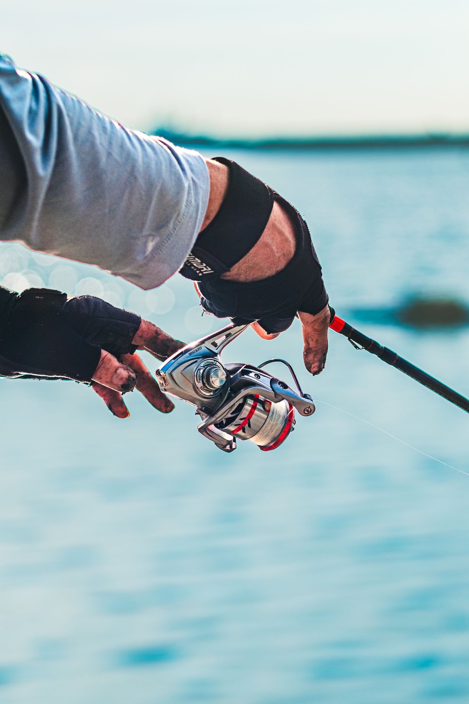 Angler holding a spinning reel by the water